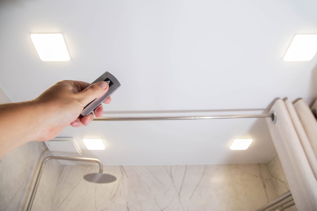 man holding remote to smart fan