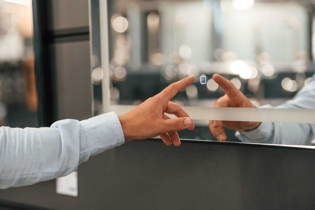 Man pressing finger to smart mirror