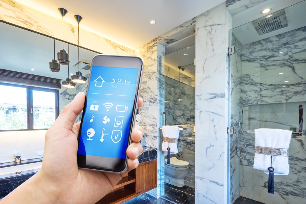Man holding an app to smart home in bathroom to activate smart shower