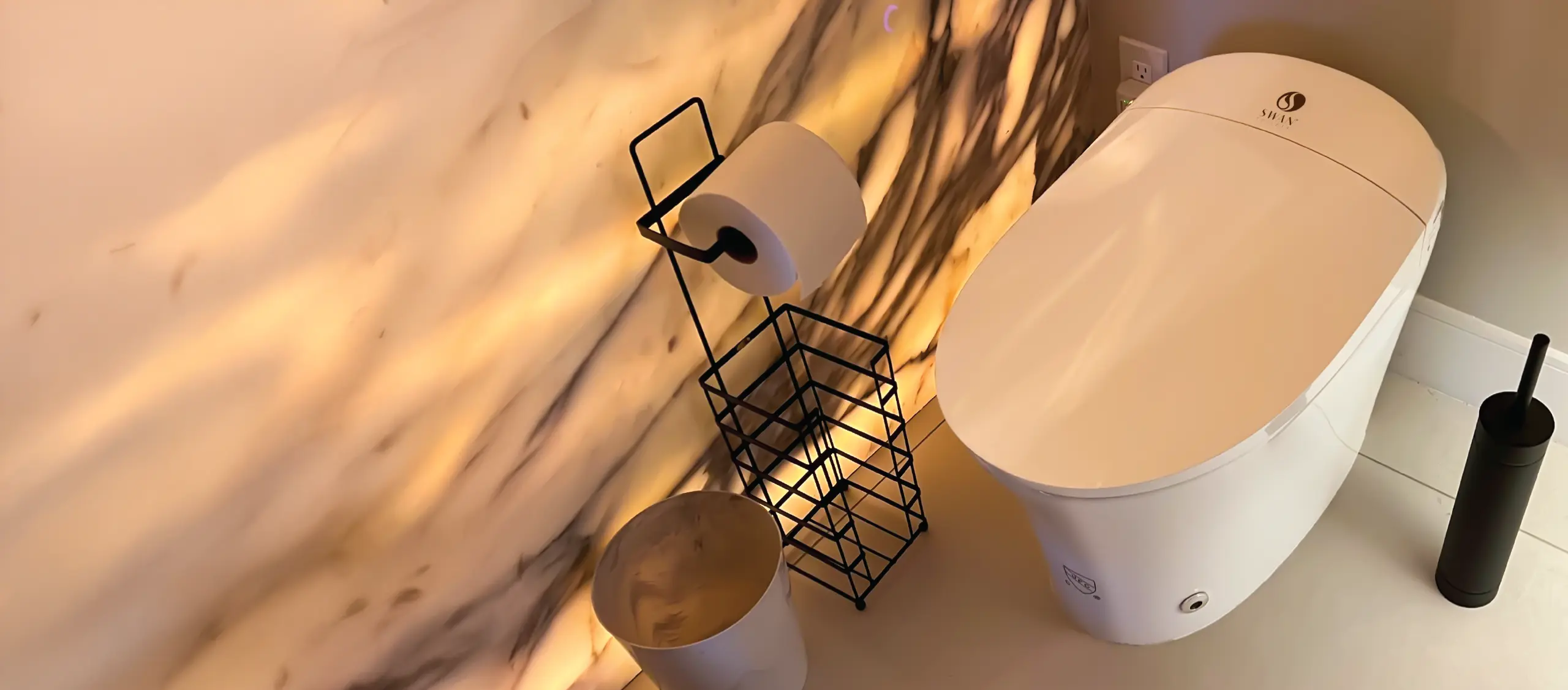 Swan S Pro Smart Toilet installed in a luxury bathroom with marble walls and ambient lighting.